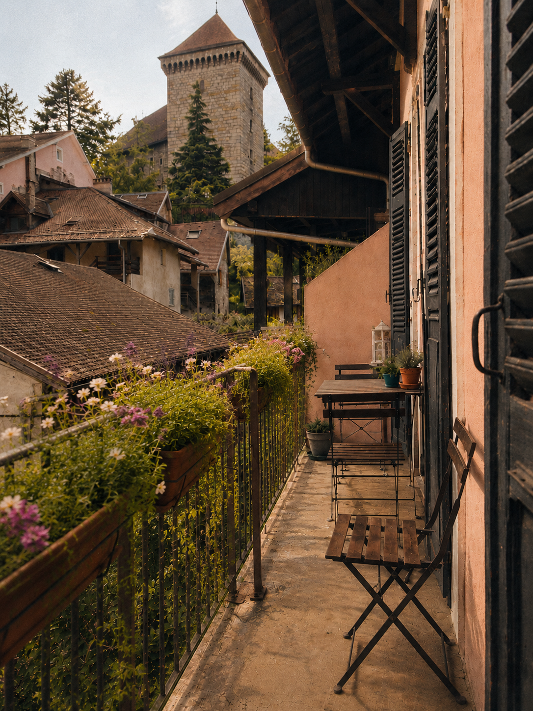 Morning light through the French balcony doors of the Annecy apartment, opening to the rooftops of the Old Town
